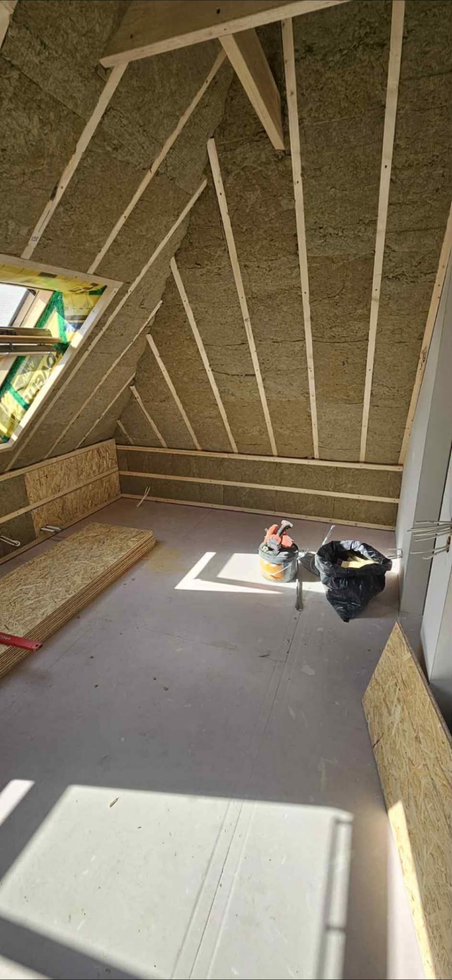 Attic under renovation with mineral wool insulation and timber battens